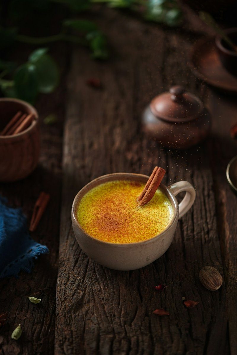 Tasse Goldene Milch auf dunklem Holz