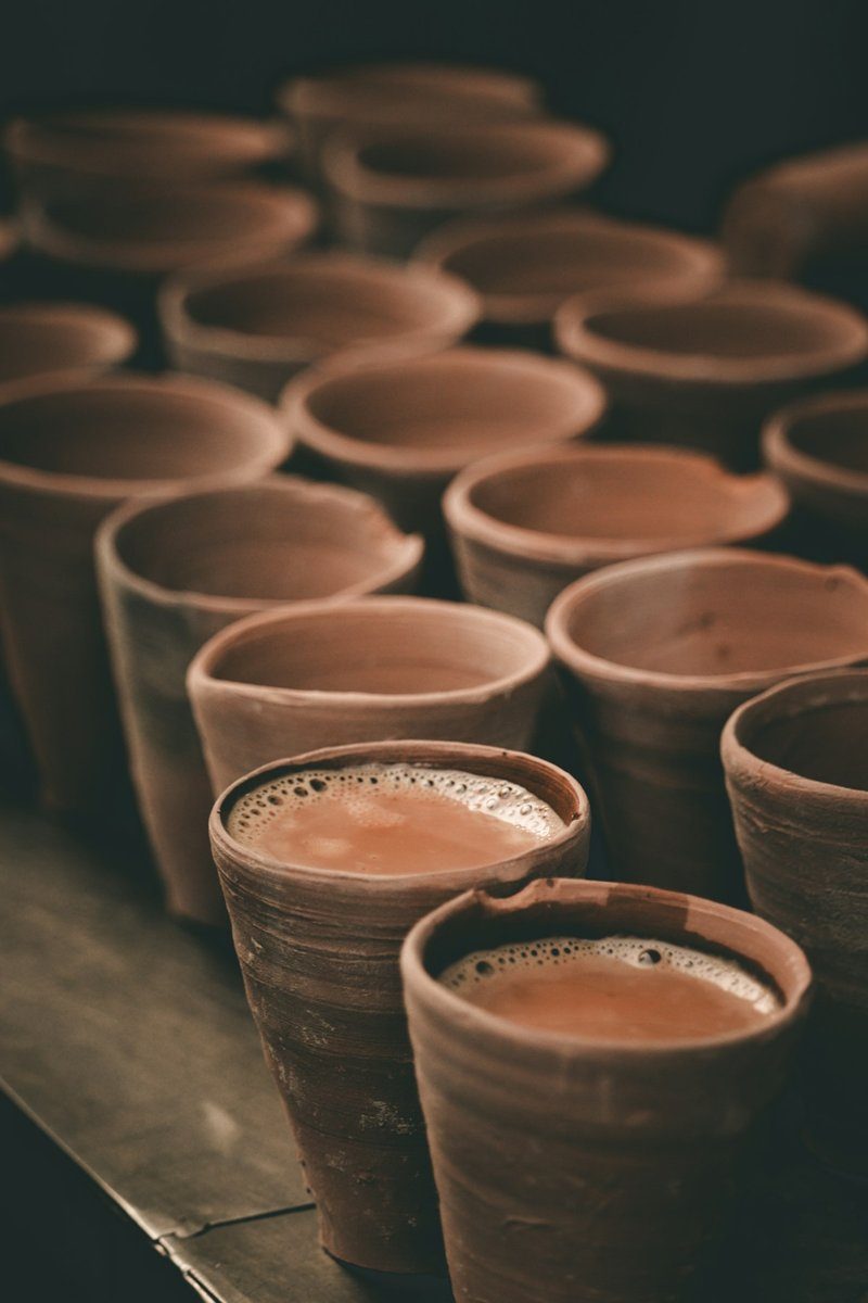 Tonbecher mit Chai auf einem Holztisch