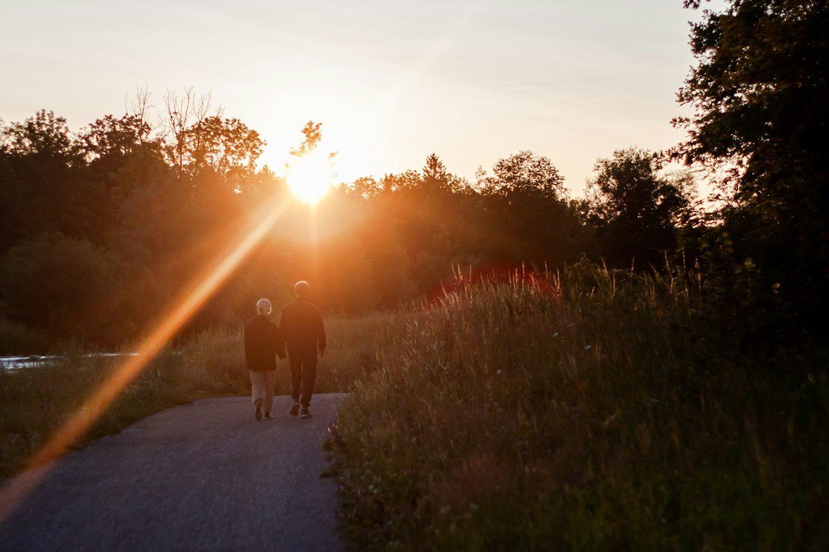 Zwei Menschen auf einem Weg im Abendlicht