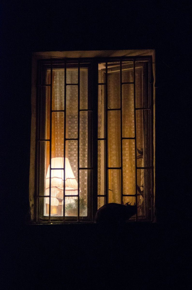 Erleuchtetes Fenster in einer dunklen Hauswand